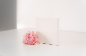 Mockup empty frame paper card with pink flower on white background, minimalism concept. Copy space, place for text or your design.