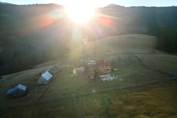 Aerial view of mountain hillside with small shepherd huts in evening