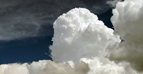 Bright landscape of white puffy cumulus clouds on blue clear sky