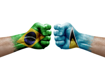 Two hands punch to each others on white background. Country flags painted fists, conflict crisis concept between brazil and saint lucia