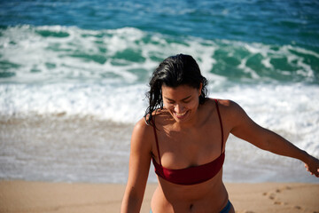 Fototapeta na wymiar A photo of a woman smiling wearing a bikini swimming suit at the beach