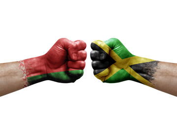 Two hands punch to each others on white background. Country flags painted fists, conflict crisis concept between belarus and jamaica