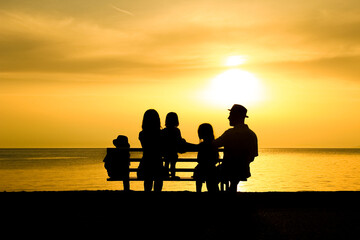 Obraz na płótnie Canvas A happy family in nature by the sea on a trip silhouette