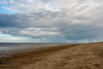 Fototapeta na wymiar Sand beach, sea and cloudy blue sky in England in sunny day