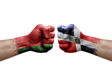 Two hands punch to each others on white background. Country flags painted fists, conflict crisis concept between belarus and dominican republic