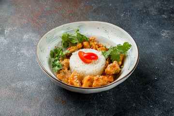 chicken in sweet and sour sauce with boiled rice on plate