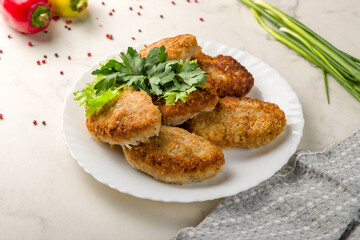 Chicken cutlets on plate on white marble table