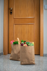 Food shopping bags stand at the door of the house or apartment. Vegetables and fruits delivery during quarantine and self-isolation.