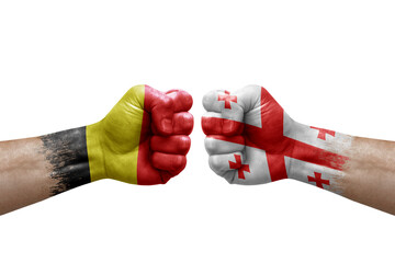 Two hands punch to each others on white background. Country flags painted fists, conflict crisis concept between belgium and georgia