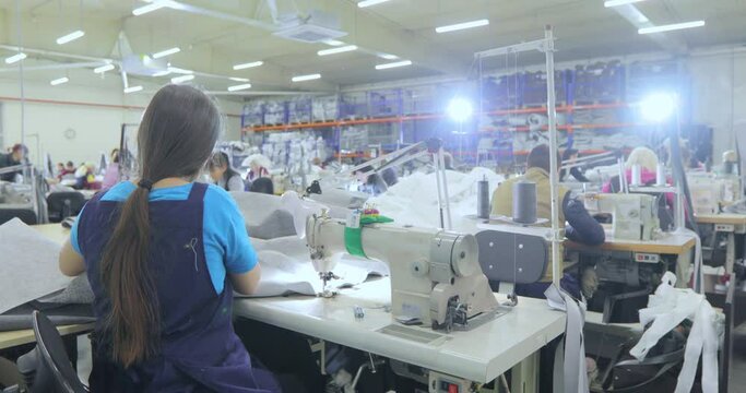A woman works in a garment factory. A woman works on a sewing machine. Making textiles in a factory