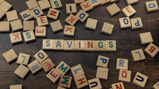 Savings word spelled from wooden block letters - zoom in shot. High quality 4k footage