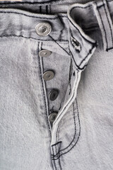 gray jeans close-up with button closure.