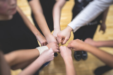 Team of kids children basketball players stacking hands in the court, sports team together holding...