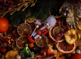 Christmas decorations - a nutcracker and, against the background of ornaments and candied fruits.