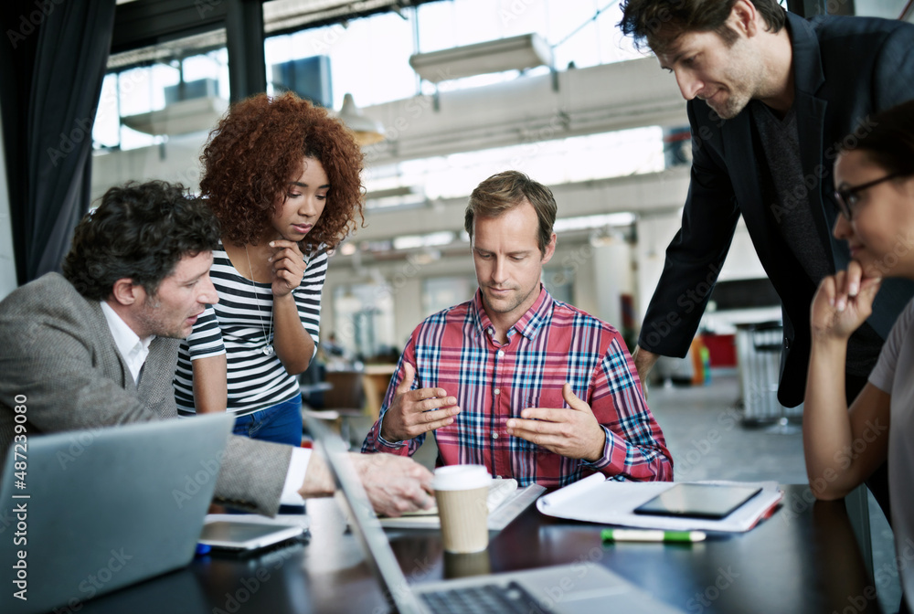 Wall mural Designing minds. Shot of office workers talking in a meeting in an office.