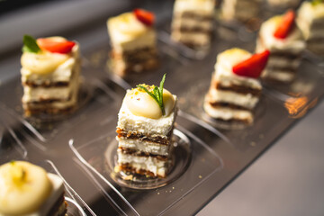 Beautiful multicolored decorated baked sweet tasty candy bar dessert on kids children party with happy people around, catering banquet table on kids children party