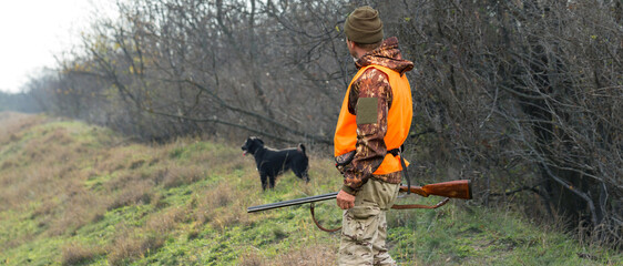 Hunter man in camouflage with a gun during the hunt in search of wild birds or game. Autumn hunting...