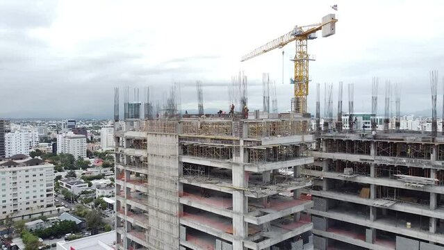 Vuelo a&eacute;reo sobre un nuevo sitio de desarrollo de construcciones. Construcci&oacute;n Urbana, Vista A&eacute;rea. La gr&uacute;a alta funciona en el lugar de construcci&oacute;n. Lugar de construcci&oacute;n de gr&uacute;as y edificios.