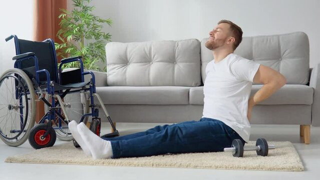 Disabled sportsman doing stretching and exercises on wheelchair background. Concept of inclusion and disability