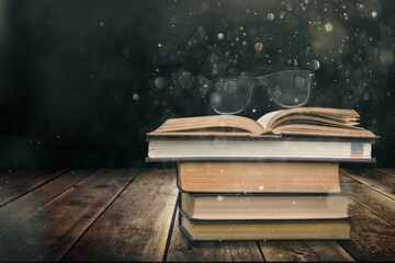 Stack of old worn shabby books in leather binding in the dark.