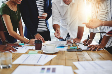 We apply creativity to get the job done. Shot of a group of unrecognizable people working together in a modern office.