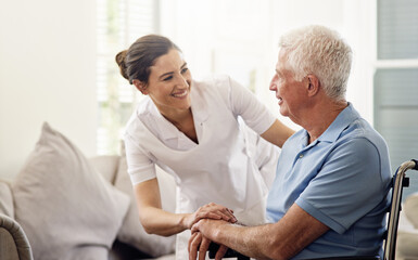 Shes always there with a helping hand. Shot of a caregiver helping a senior man in a wheelchair at home.