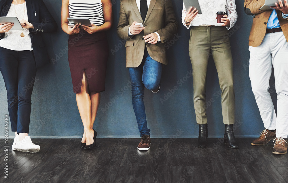 Poster getting their feet into the door of business. cropped studio shot of a group of businesspeople using