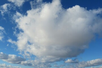 Obraz premium Big fluffy cloud in blue sky, natural clouds background
