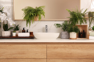 Fototapeta na wymiar Counter with sink and many different houseplants near white marble wall