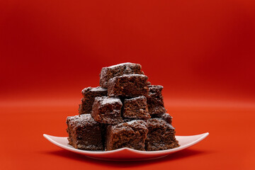 Brownies on white plate and red background