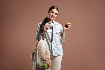 Woman with eco bags and pear on pink background