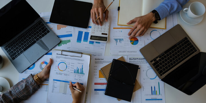 Business People Meeting Design Ideas Concept. Group of Investor diverse brainstorm and pointing at laptop computer on wooden desk. Finance concpet. - Powered by Adobe