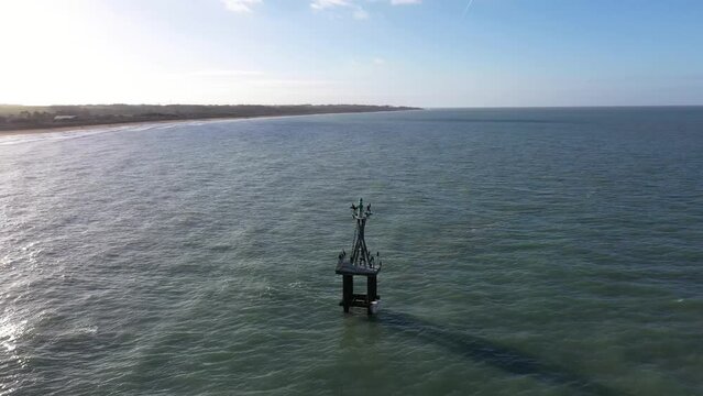 drone shot of a marine beacon in courseulles-sur-mer on a beautiful sunseet