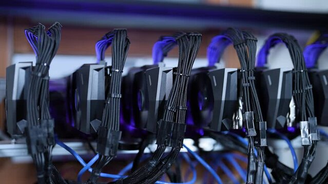 Cryptocurrency Mining Rack with Video Card Rigs in a row connected by wires from power supply, GPU, Motherboards. Industrial  Mining Farm for Cryptocurrencies: Altcoins, Ethereum and Bitcoin. BTC. IT