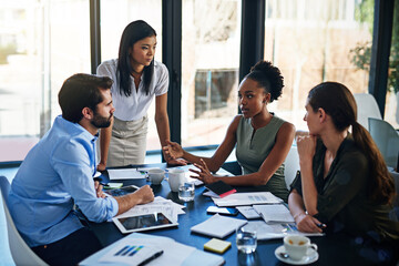 Shes bringing new ideas to the team. Shot of a group of businesspeople having a meeting in a...