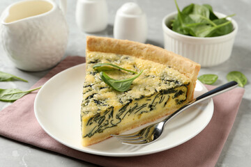 Piece of delicious spinach pie served on light table, closeup