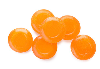 Many orange cough drops on white background, top view