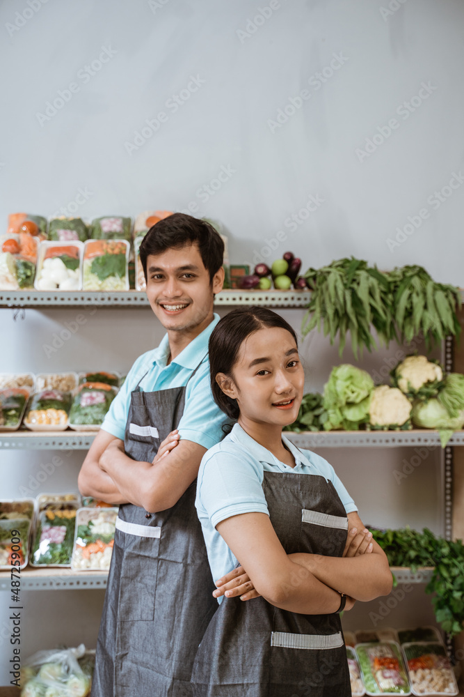 Wall mural woman and man greengrocer standing folded hands