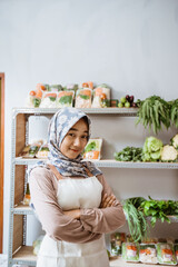 Girl in hijab selling vegetables smiling with folded hands