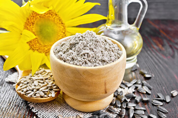 Flour sunflower in bowl with flower on wooden board © kostrez