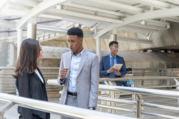 Group of business people.Business people meeting talking and sharing their ideas in city. Business team and teamwork concept. Business people standing outside in the city discussing about new project.