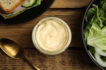 Flat lay composition with jar of delicious mayonnaise on wooden table