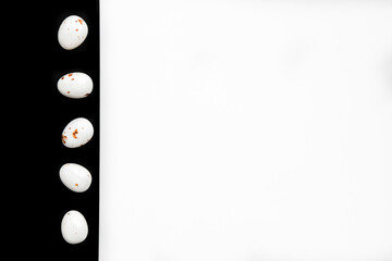 Easter minimal composition with multicolored eggs on the white black background. Easter concept. Copy space, flat lay.