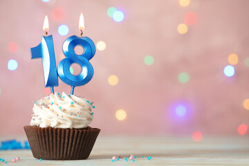 18th birthday, coming of age party. Delicious cupcake with number shaped candles on white table, space for text