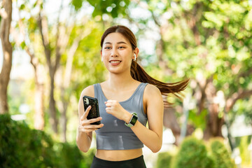 Running Asian woman. Female Runner Jogging during Outdoor Workout in a Park. Asian woman running in garden. Her morning exercise.Young Asian Girl doing yoga in the park