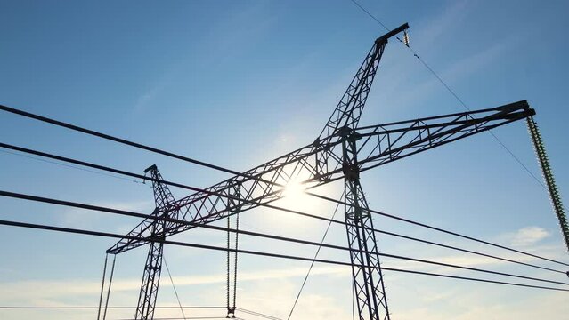 High voltage tower with electric power lines divided by safe guard bushing transfening safely electrical energy through cable wires. Electricity transmission on long distance concept