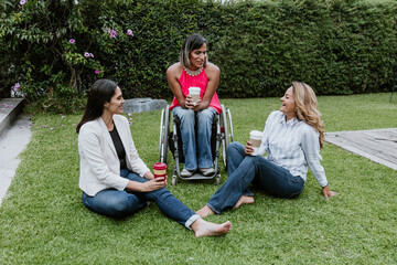 Latin business woman transgender on wheels chair and friends sitting on grass and meditating at...