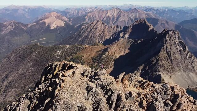 Orbiting around a person standing on top of the mountain in South Rockies, Canada