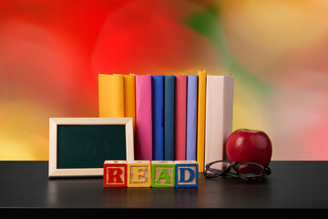 Stack of books on wooden table against blurred background