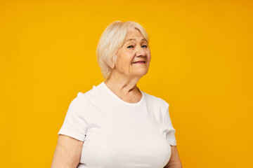 elderly woman in casual t-shirt gestures with his hands isolated background